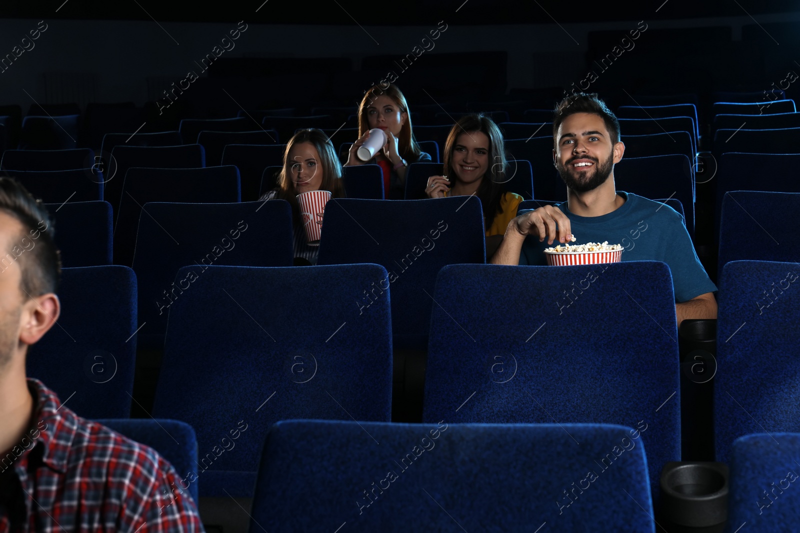 Photo of Young people watching movie in cinema theatre