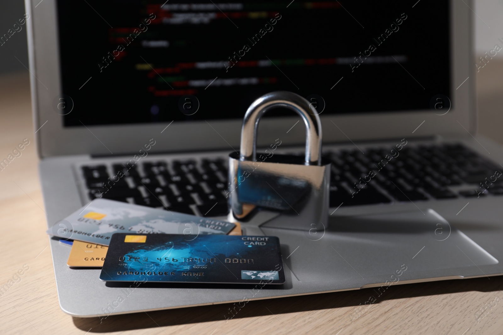 Photo of Credit cards, lock and laptop on wooden table, closeup. Cyber crime