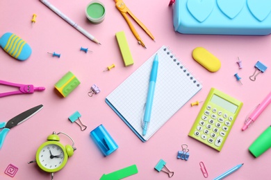Photo of Bright school stationery on pink background, flat lay