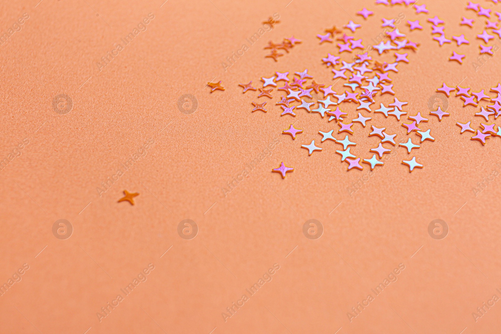 Photo of Shiny bright glitter on pink background. Space for text