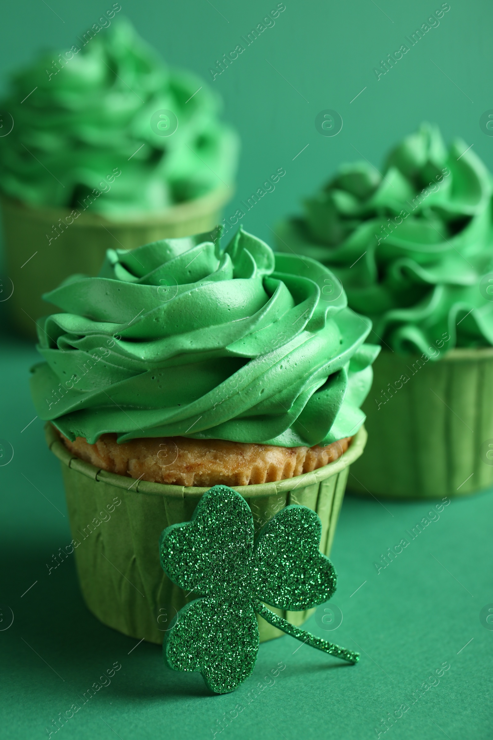 Photo of St. Patrick's day party. Tasty cupcakes on green background, closeup