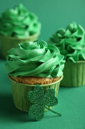 St. Patrick's day party. Tasty cupcakes on green background, closeup