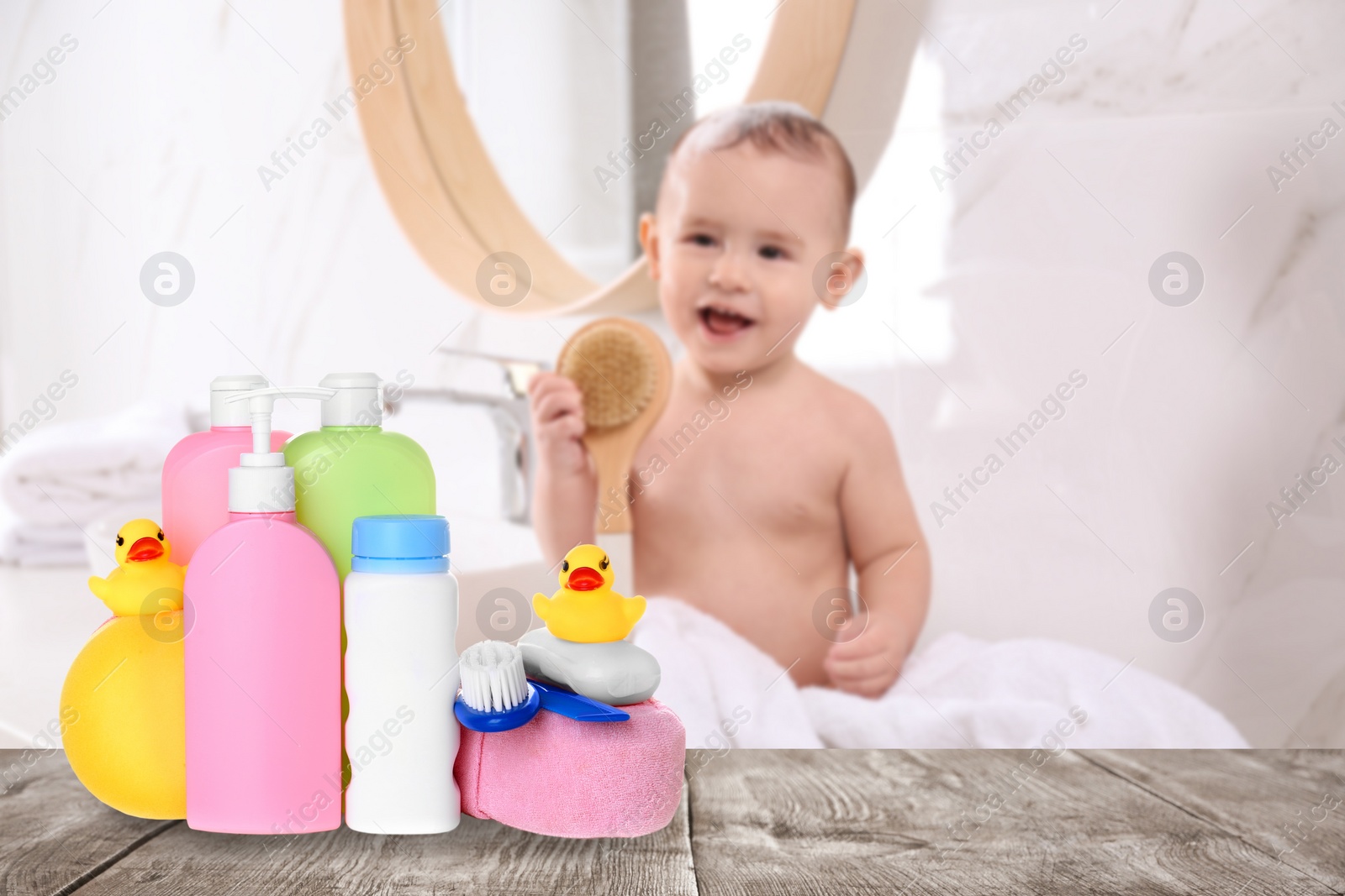 Image of Baby cosmetic products, toys and bathing accessories on table in bathroom