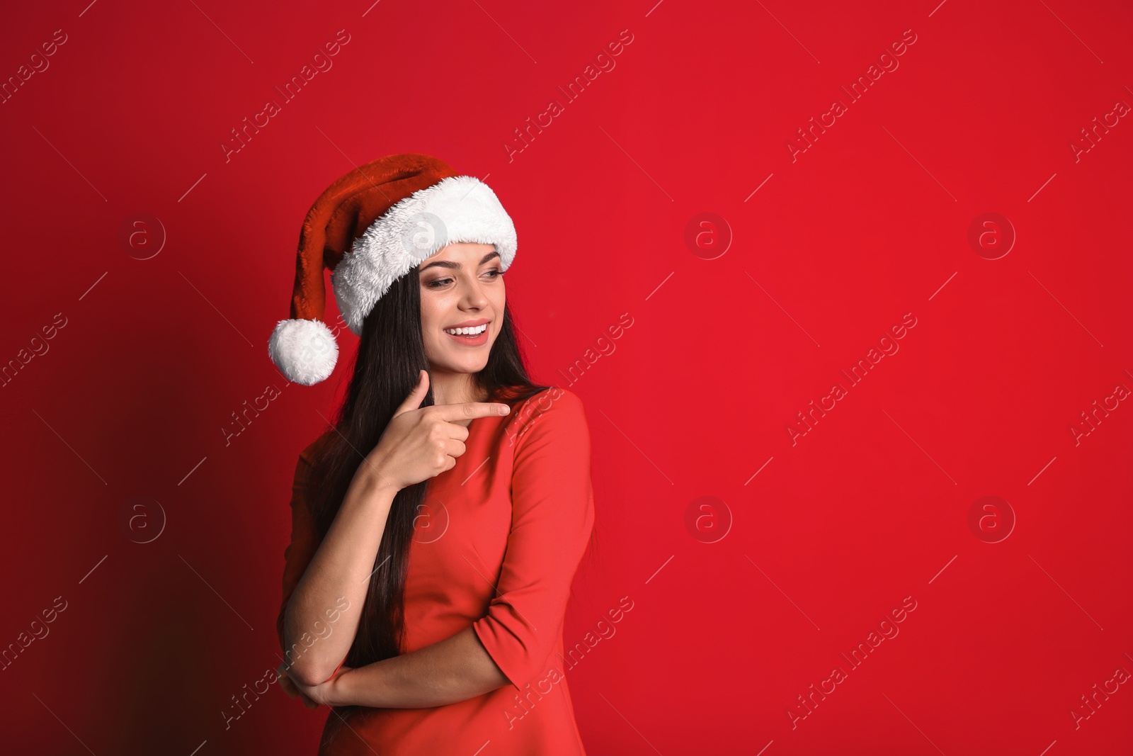 Photo of Young beautiful woman in Santa hat on color background. Christmas celebration