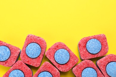 Photo of Many dishwasher detergent tablets on yellow background, flat lay. Space for text