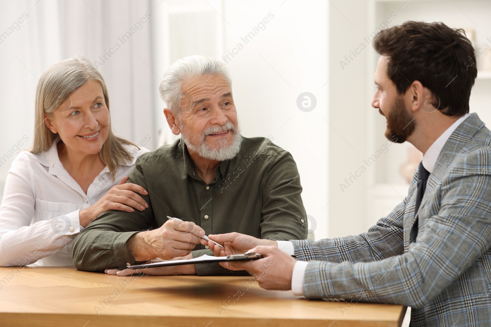 Photo of Notary consulting senior couple about Last Will and Testament in office