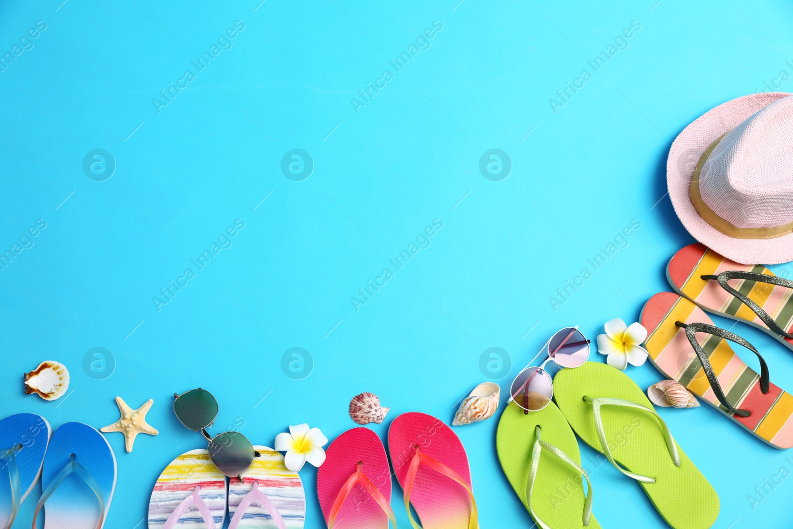 Photo of Flat lay composition with different flip flops on blue background, space for text. Summer beach accessories