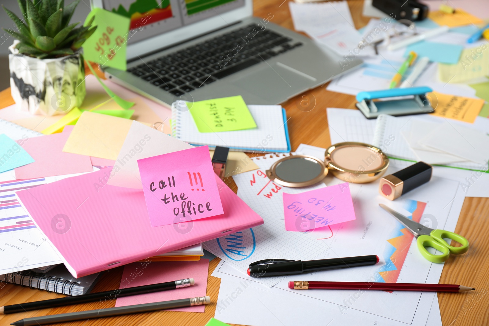 Photo of Messy table with laptop and cosmetics. Concept of being overwhelmed by work