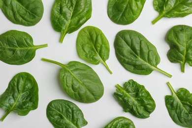 Photo of Fresh leaves of spinach isolated on white, top view