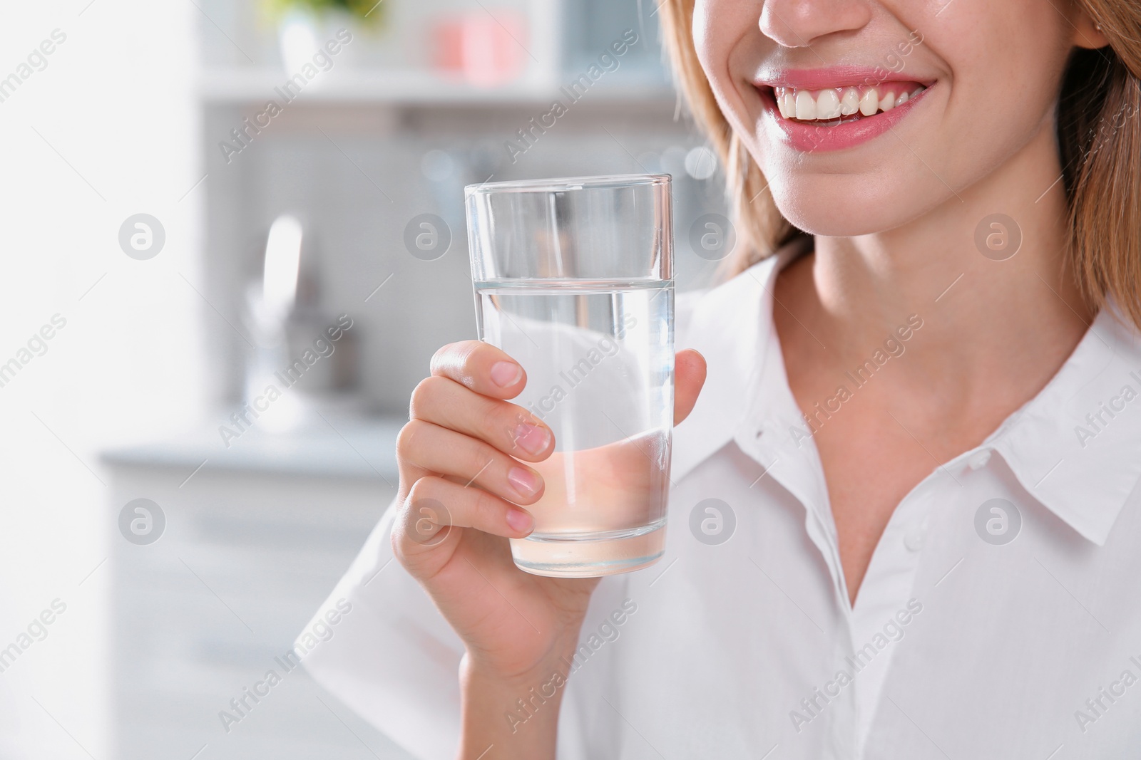 Photo of Woman drinking clean water from glass in kitchen, closeup