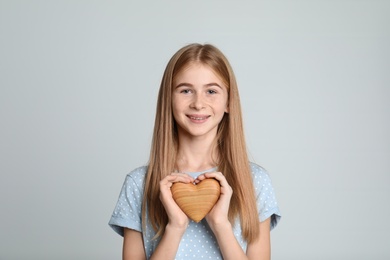 Photo of Pretty teenage girl with decorative heart on color background