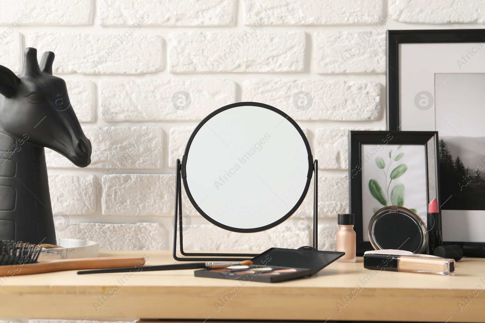 Photo of Dressing table with mirror, makeup products and accessories in room