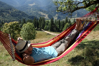 Photo of Man resting in hammock outdoors on sunny day