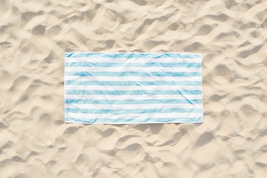 Image of Striped beach towel on sand, aerial view