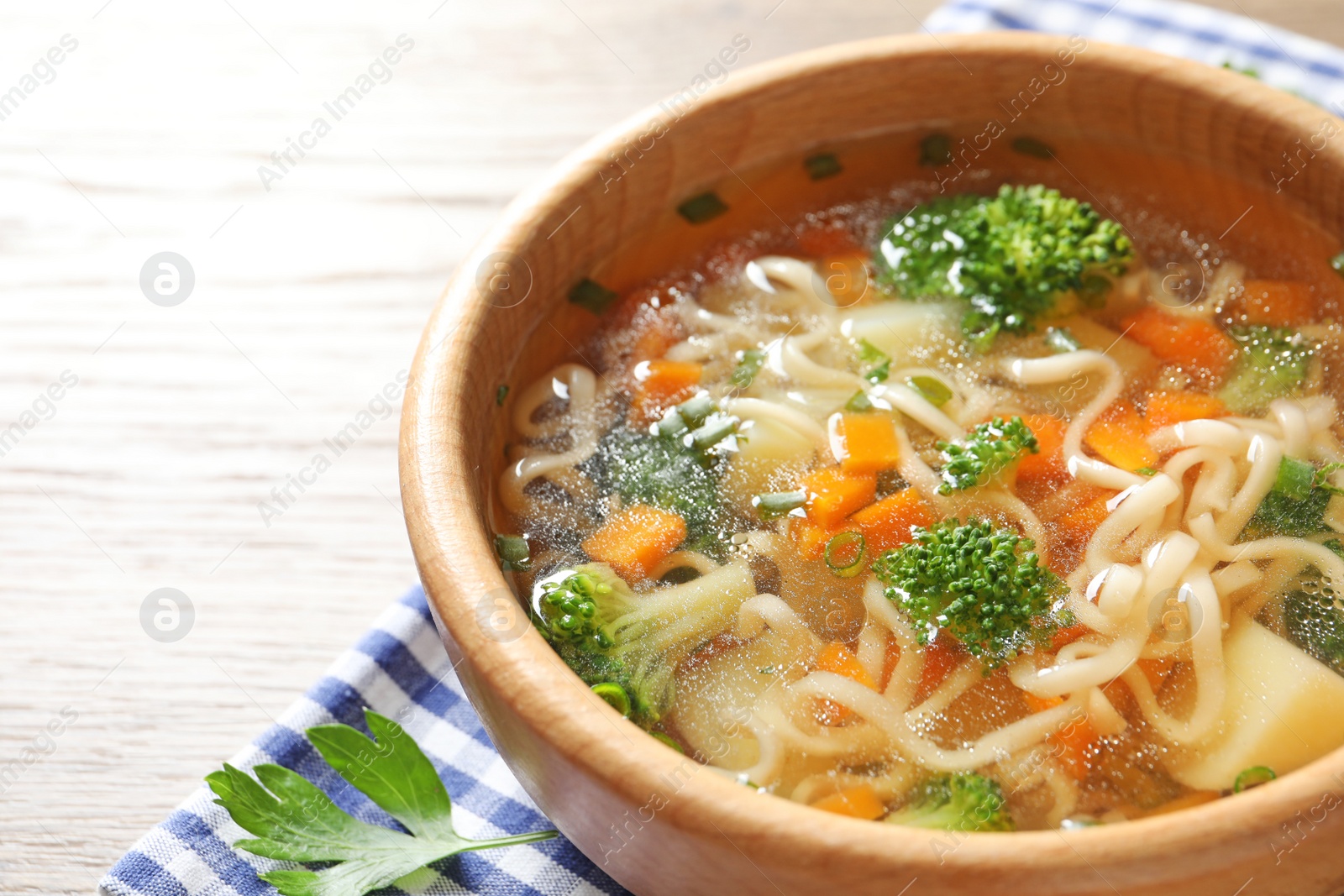 Photo of Bowl of fresh homemade vegetable soup on wooden background, closeup