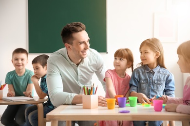 Cute little children with teacher in classroom at school