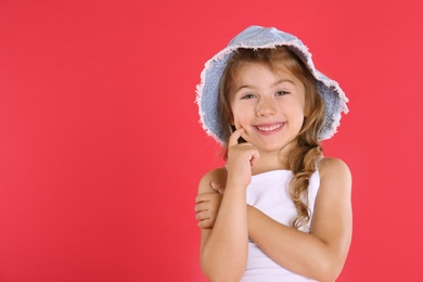 Photo of Portrait of cute little girl on red background. Space for text