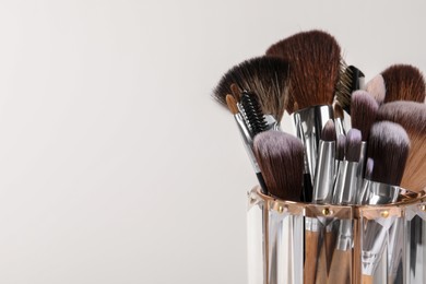 Photo of Set of professional makeup brushes on white background, closeup. Space for text