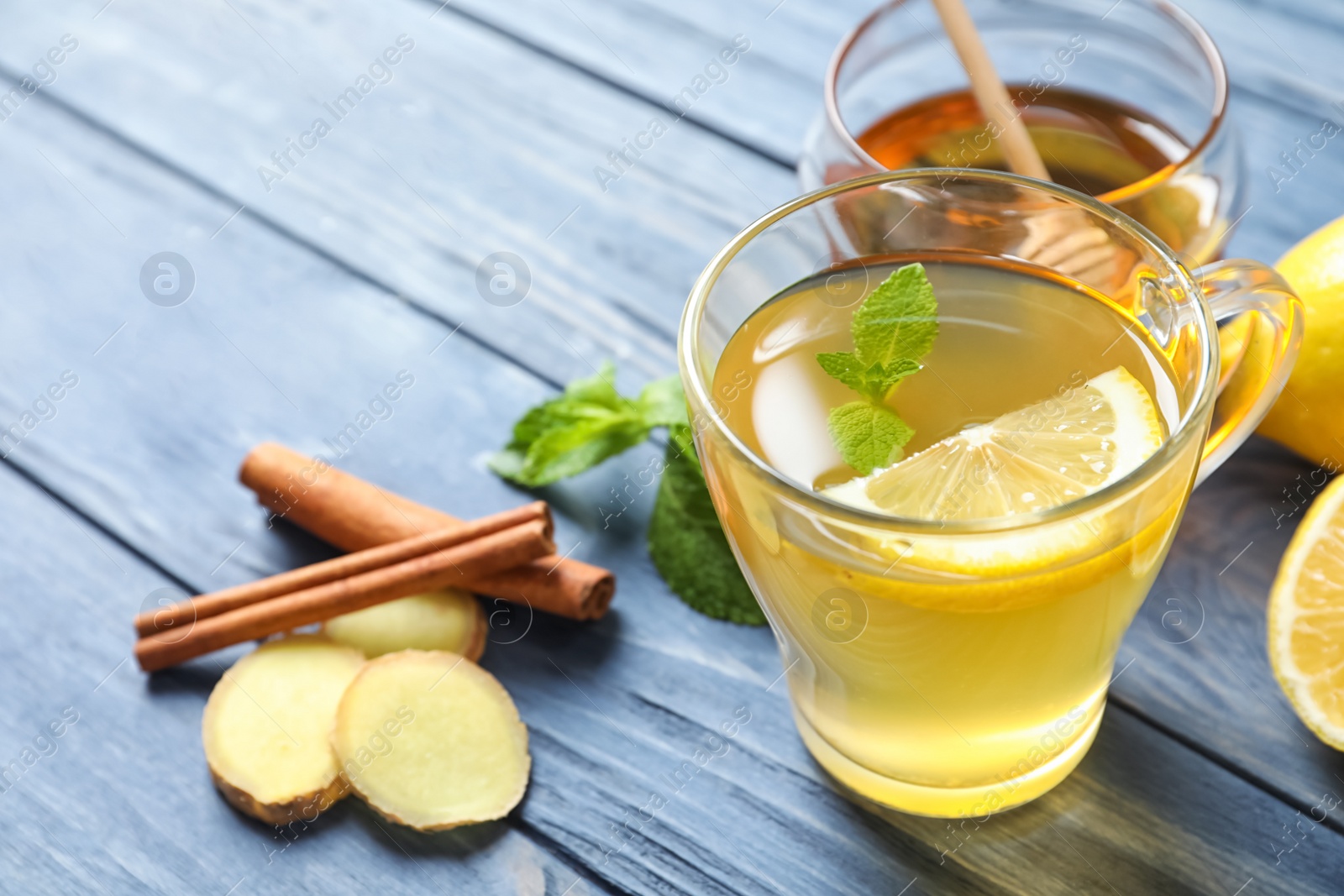 Photo of Cup with hot tea and lemon for cold on wooden table