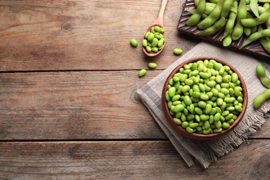 Photo of Delicious edamame beans on wooden table, flat lay. Space for text