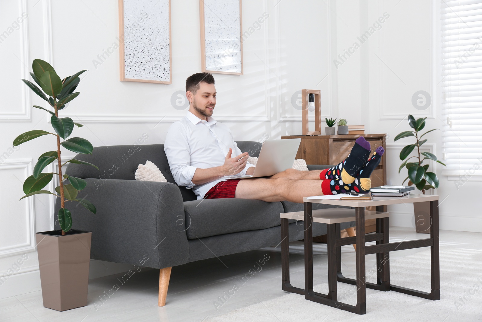 Photo of Businessman wearing shirt and underwear during video call at home