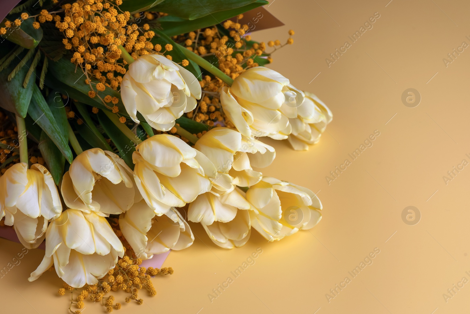 Photo of Bouquet with beautiful tulips and mimosa flowers on yellow background. Space for text
