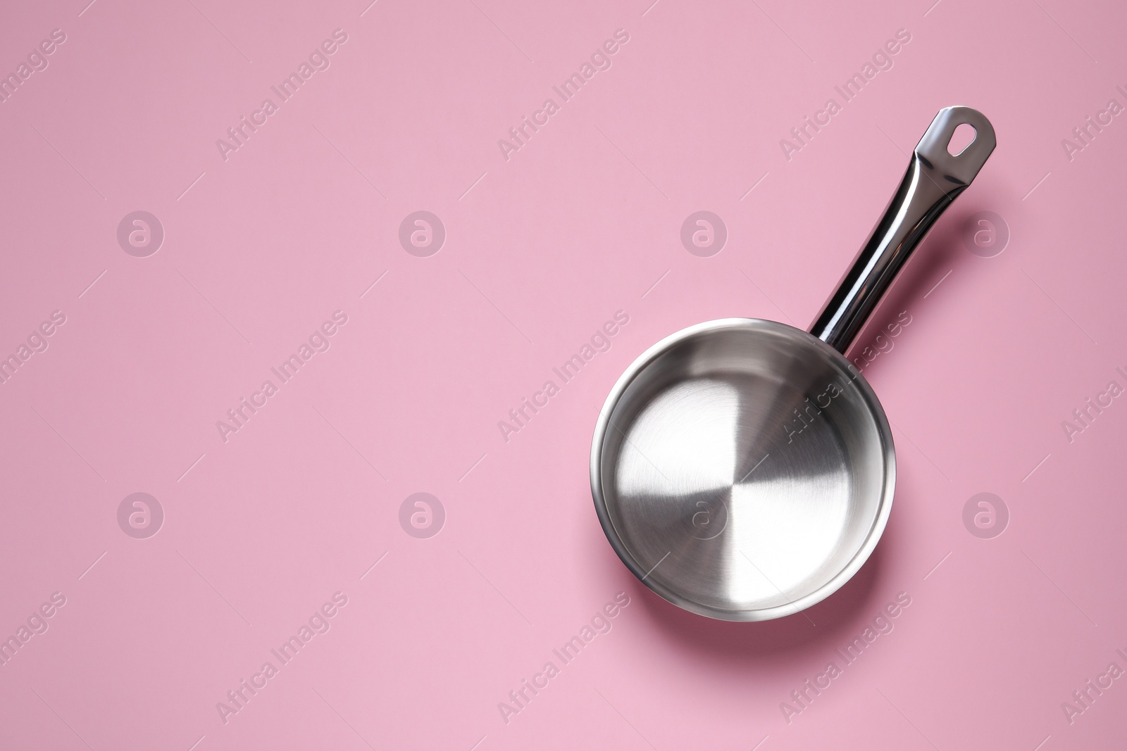 Photo of Empty steel saucepan on pink background, top view. Space for text