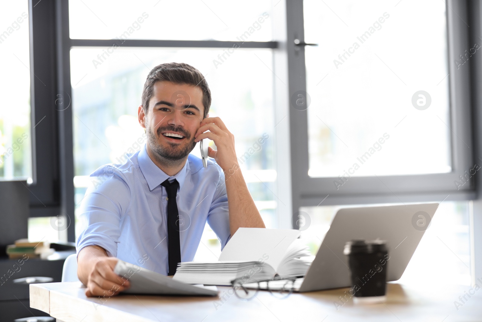 Photo of Male business trainer talking on phone in office