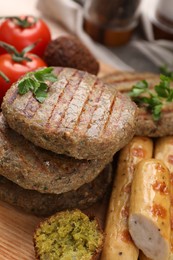 Different tasty vegan meat products on wooden table, closeup