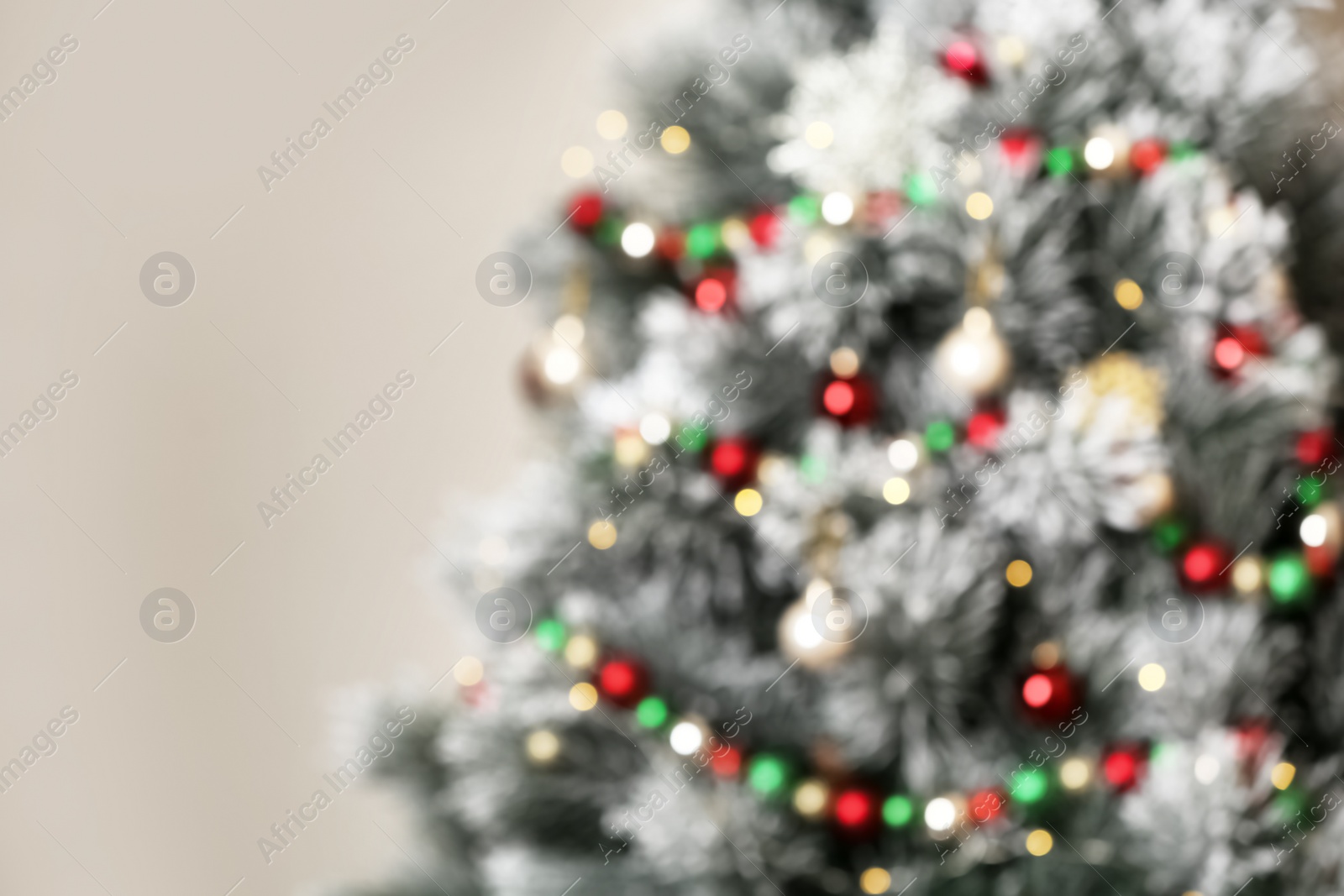 Photo of Beautiful Christmas tree with lights against grey background, blurred view. Space for text