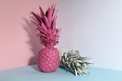 Pink and white pineapples on color background, space for text. Creative concept