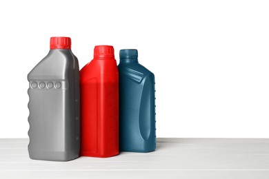 Different bottles on wooden table against white background