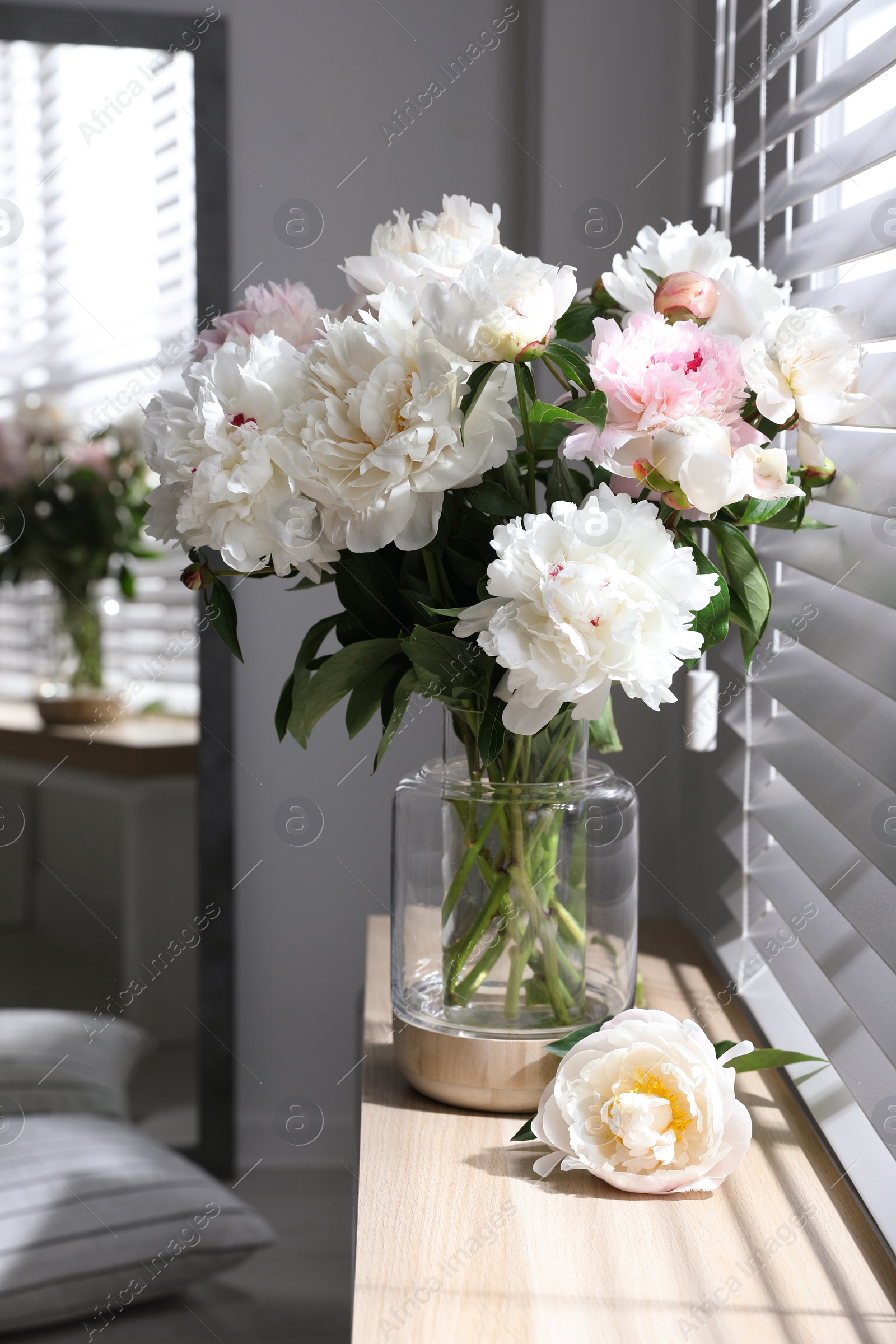 Photo of Bouquet of beautiful peony flowers on window sill indoors