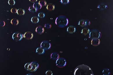 Photo of Beautiful transparent soap bubbles on dark background