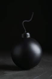 Photo of Sphere shaped bomb with burning fuse on black background