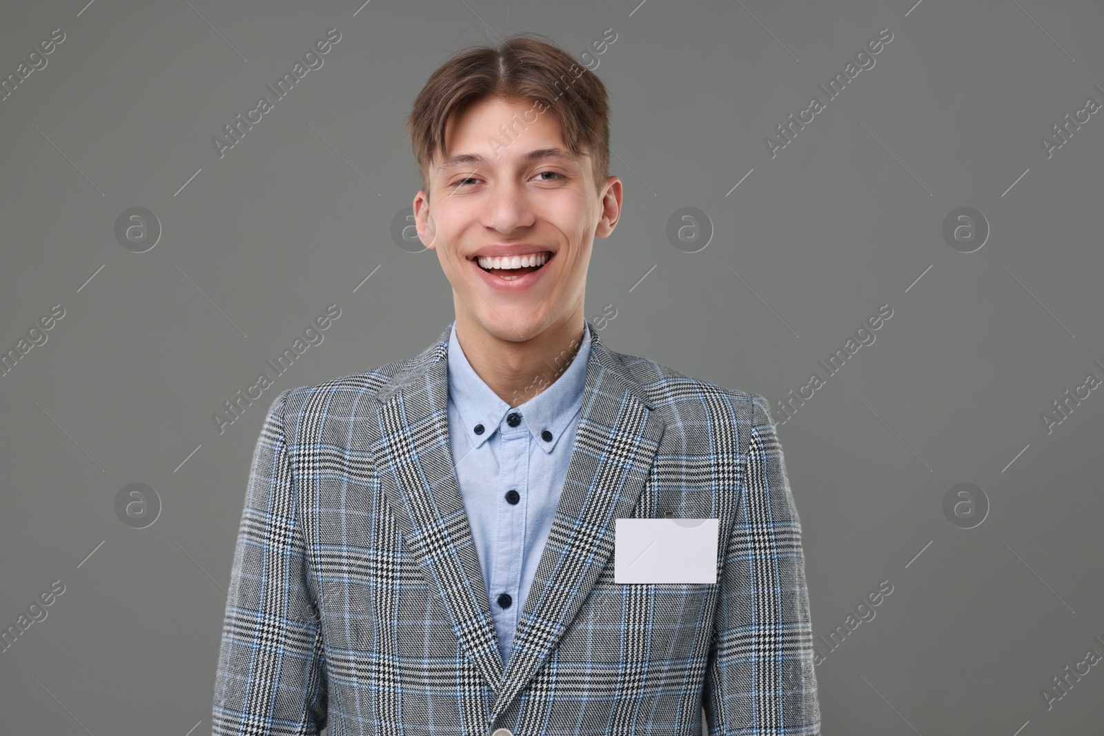 Photo of Happy man with blank badge on grey background