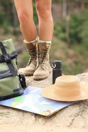 Photo of Camping equipment and woman in boots on rock, closeup