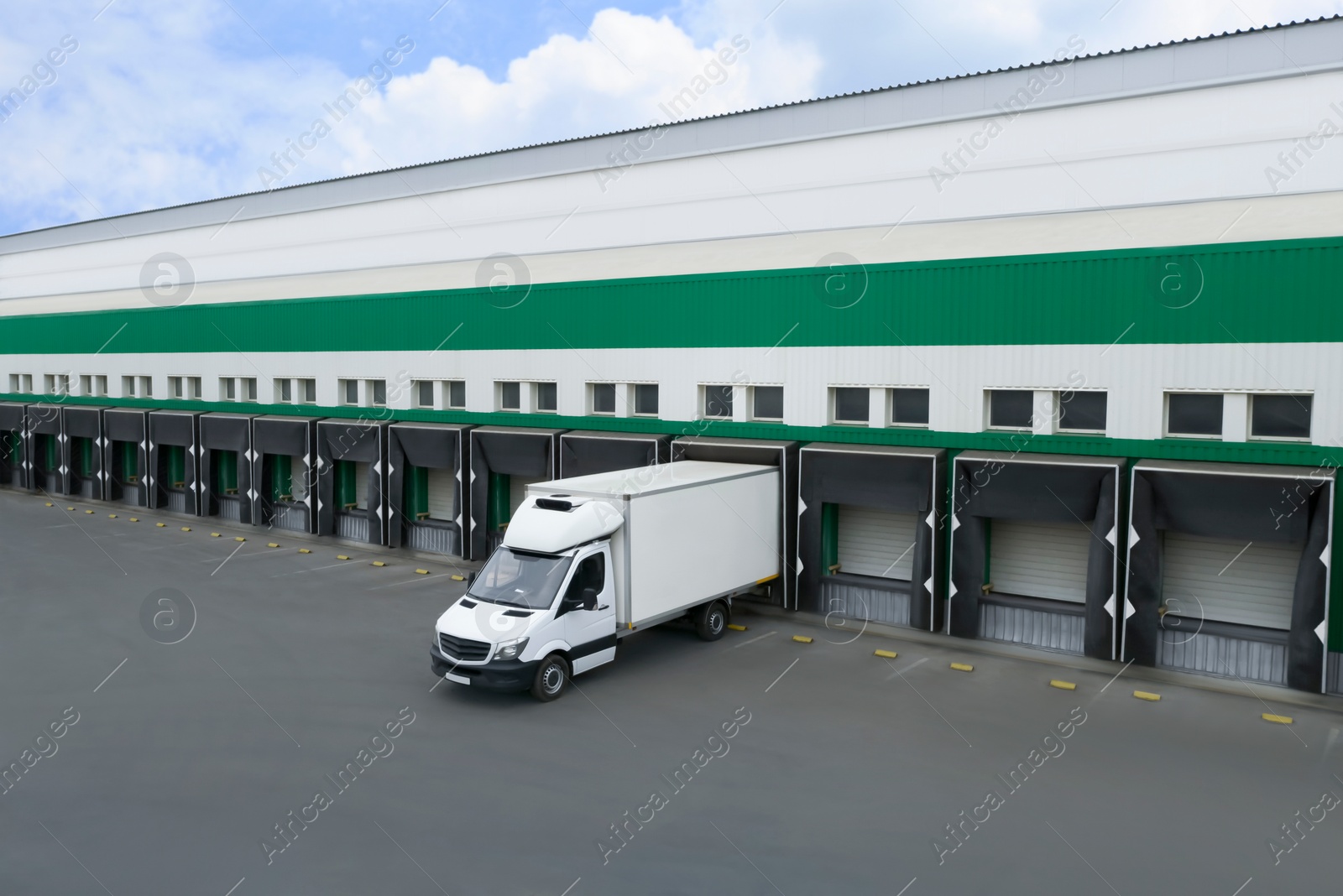 Image of Truck near loading dock of warehouse outdoors, aerial view. Logistics center