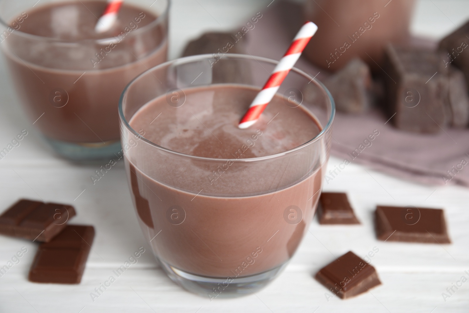 Photo of Delicious chocolate milk on white wooden table