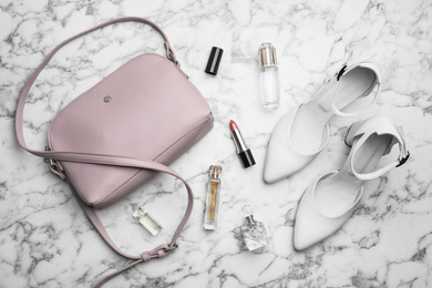 Photo of Flat lay composition with stylish shoes, cosmetics and woman's bag on white marble table