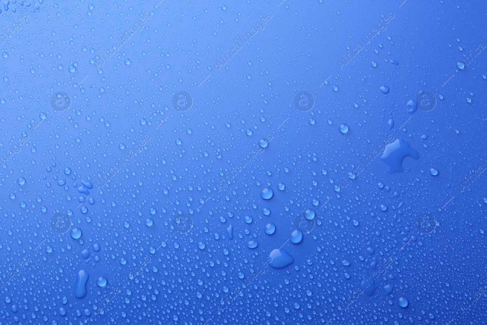 Photo of Water drops on blue background, top view