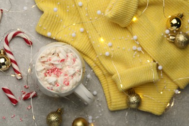 Photo of Flat lay composition with delicious marshmallow drink, festive decor and yellow sweater on light grey table