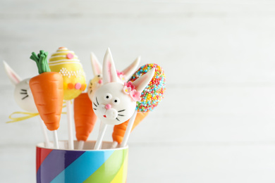 Delicious sweet cake pops on light background, space for text. Easter holiday