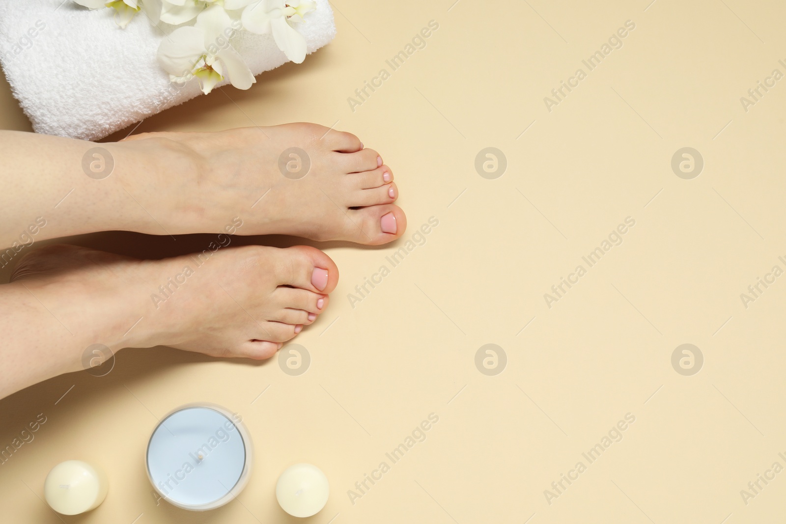 Photo of Closeup of woman with neat toenails after pedicure procedure on beige background, top view. Space for text