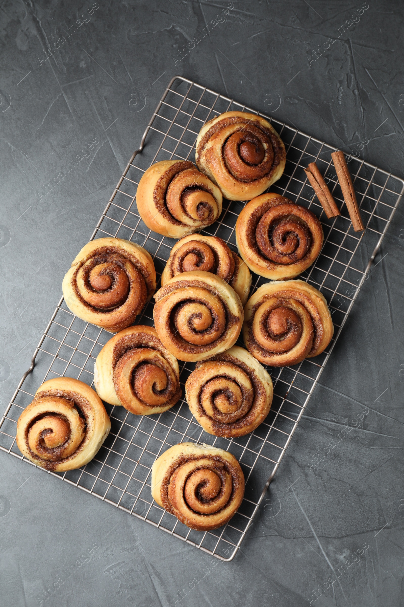 Photo of Tasty cinnamon rolls on black table, top view