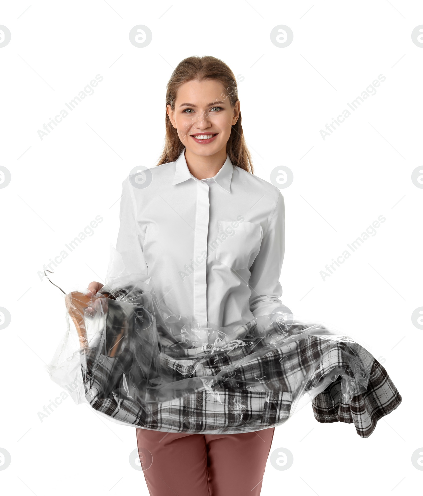 Photo of Young woman holding hanger with dress in plastic bag on white background. Dry-cleaning service