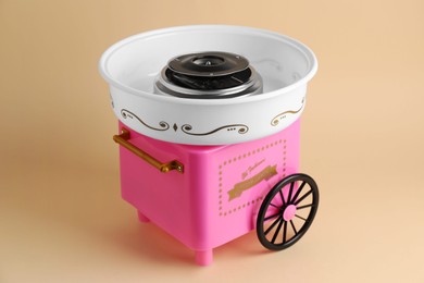 Photo of Portable candy cotton machine on beige background