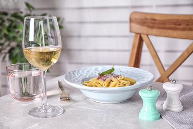 Photo of Delicious pasta with tomato sauce served on light marble table