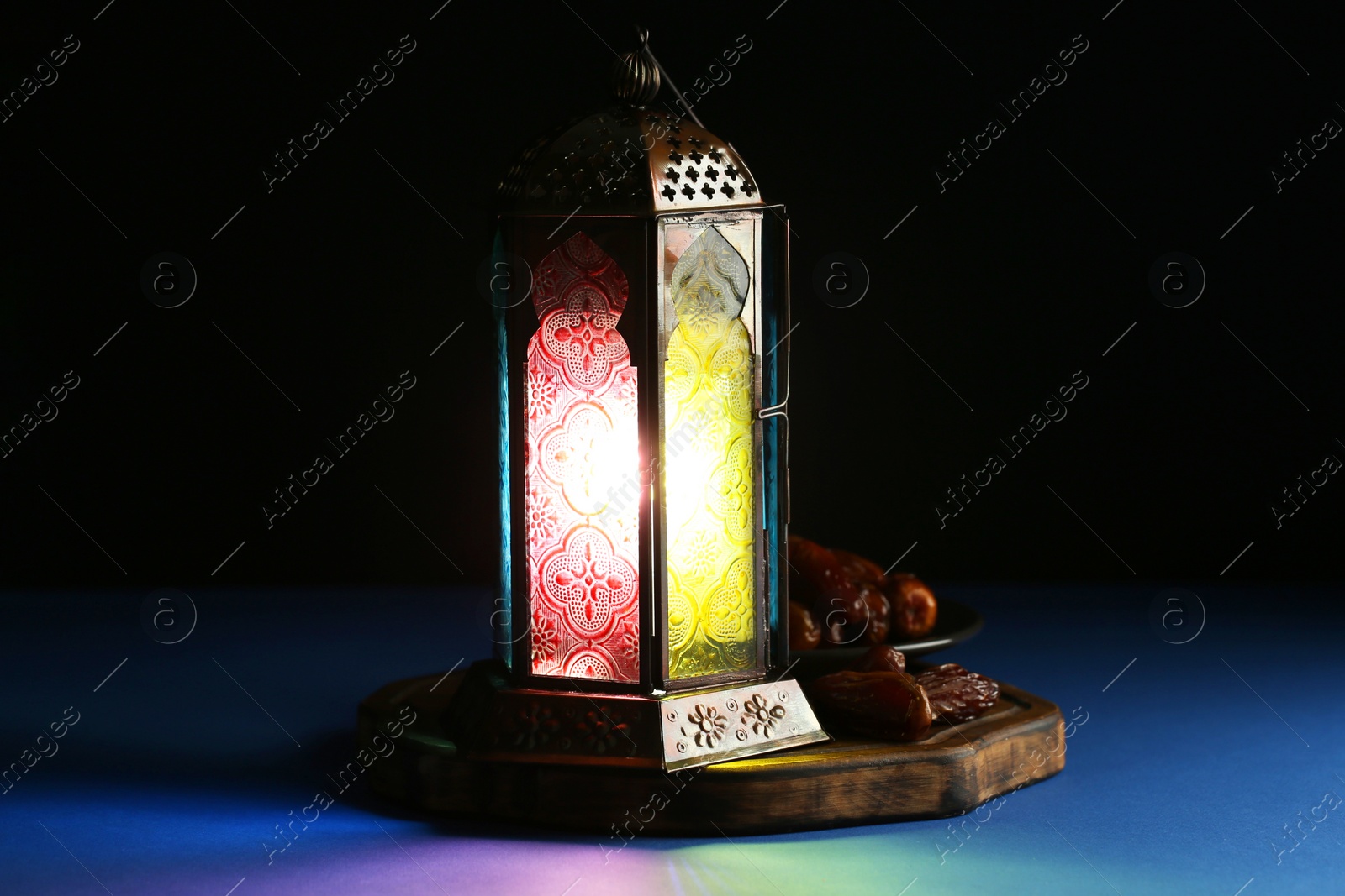 Photo of Decorative Arabic lantern and dates on table against dark background. Space for text