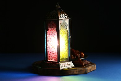 Decorative Arabic lantern and dates on table against dark background. Space for text